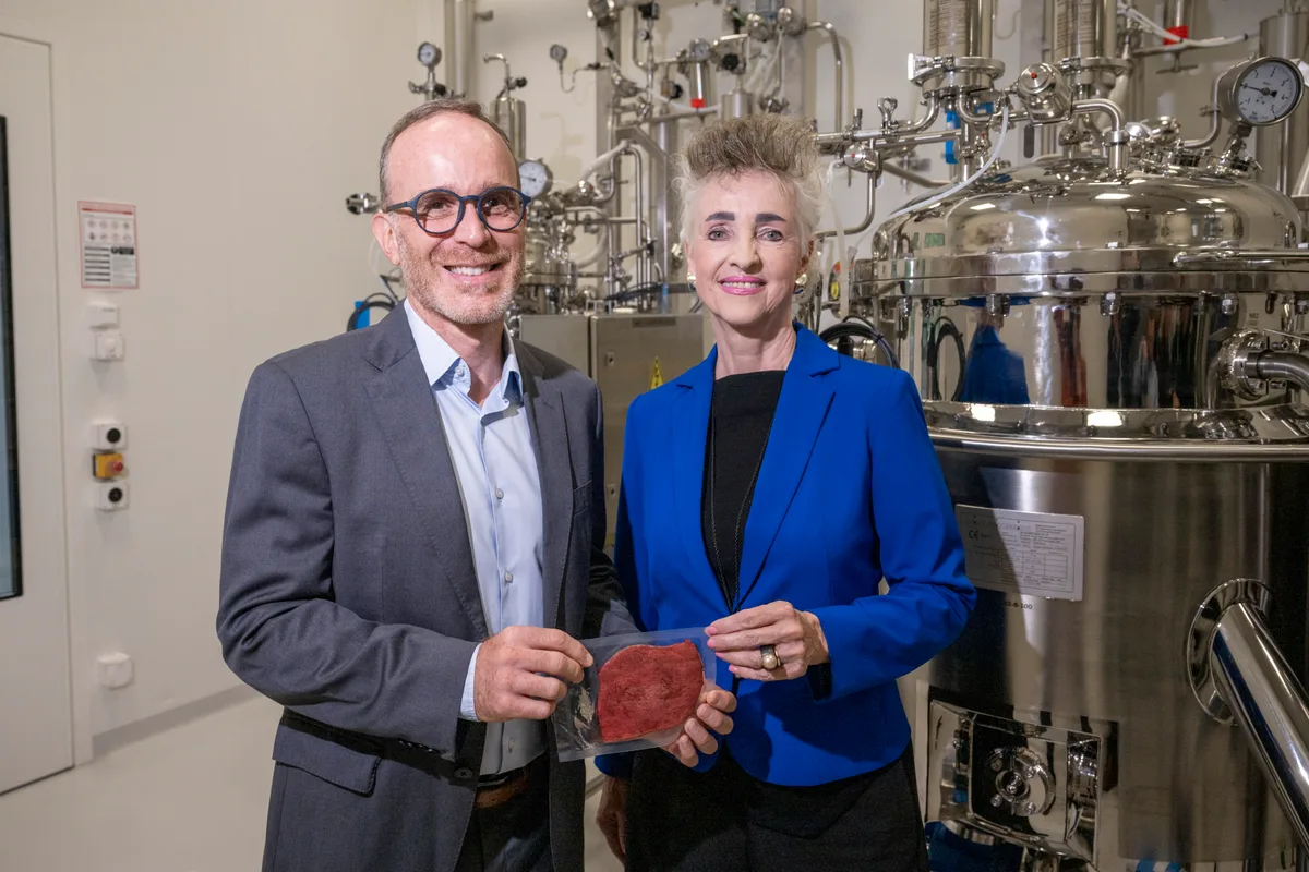 Man sieht Didier Toubia und Carmen Walker Späh vor einer industriellen Anlage stehen.